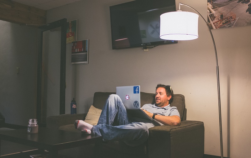 man using laptop on his couch