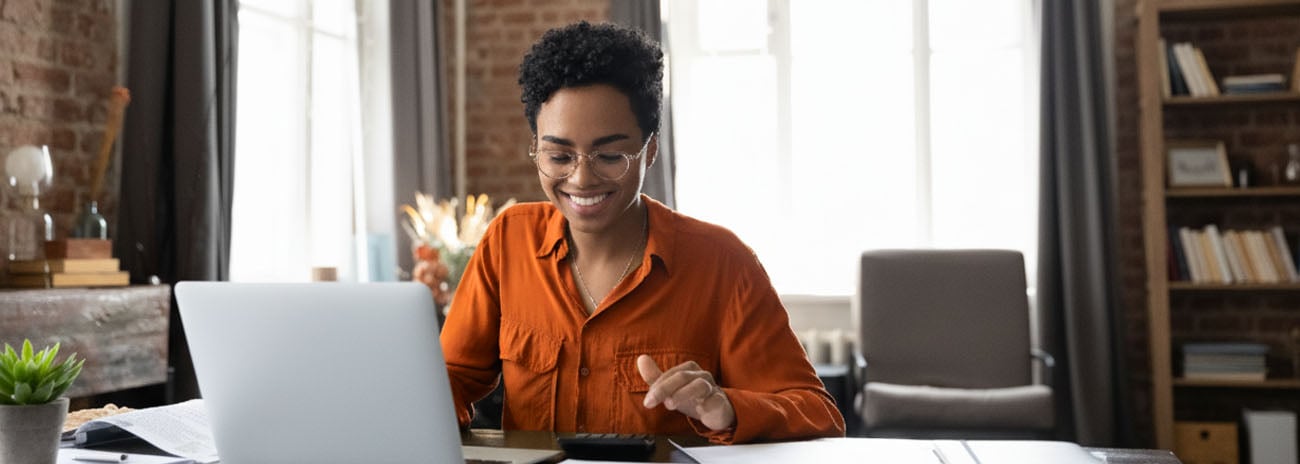 Woman preparing tax and compliance paperwork on a laptop